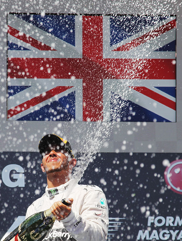 Lewis Hamilton of Great Britain and Mercedes GP celebrates on the podium after winning the Hungarian Formula One Grand Prix at Hungaroring in Budapest, Hungary, on Sunday