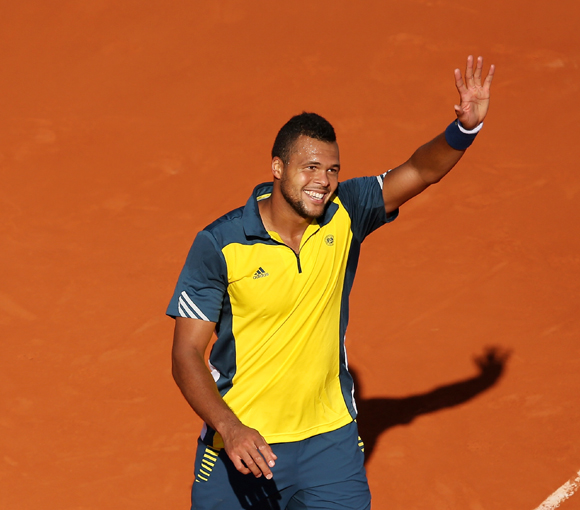 Jo-Wilfried Tsonga of France waves to crowd after victory against Roger Federer of Switzerland