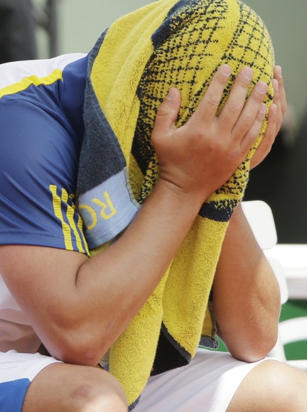 Mikhail Youzhny of Russia covers his head with a towel