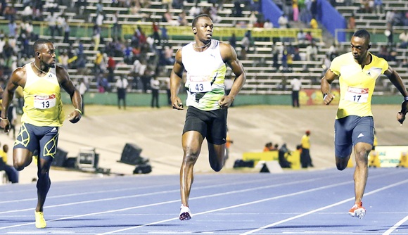 Usain Bolt (centre) crosses the finish line