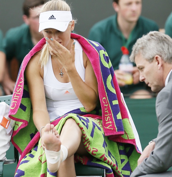 Caroline Wozniacki of Denmark reacts as she receives medical attention