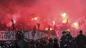 Police officers react as chaos erupts at a soccer stadium in Port Said city