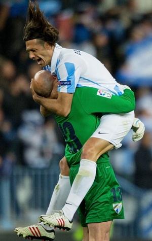 Martin G. Demichelis (R) of Malaga CF celebrates their first goal scored by his teammate Isco with goalkeeper Wilfredo Caballero 