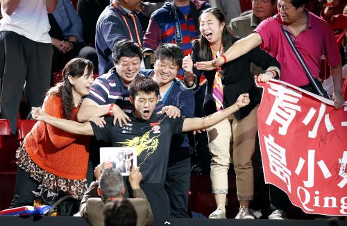 China's Zhang Jike (C) reacts among family members after defeating his compatriot Wang Hao in the men's singles final at the World Team Table Tennis Championships in Paris