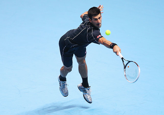 Novak Djokovic of Serbia hits a backhand in his men's singles match against Juan Martin Del Potro of Argentina during their ATP Tour Finals match on Thursday