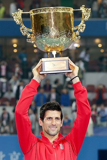 Novak Djokovic of Serbia poses celebrates with the trophy after defeating Rafael Nadal of Spain during the final of the 2013 China Open at the National Tennis Center in Beijing, on Sunday
