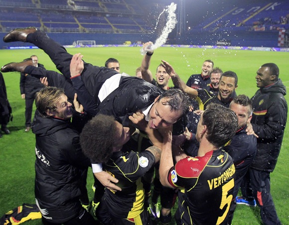 Belgium's coach Marc Wilmots is lifted in the air by players as they celebrate