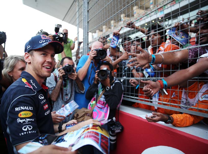 Red Bull driver Sebastian Vettel signs autographs for fans at the Buddh International Circuit in Noida