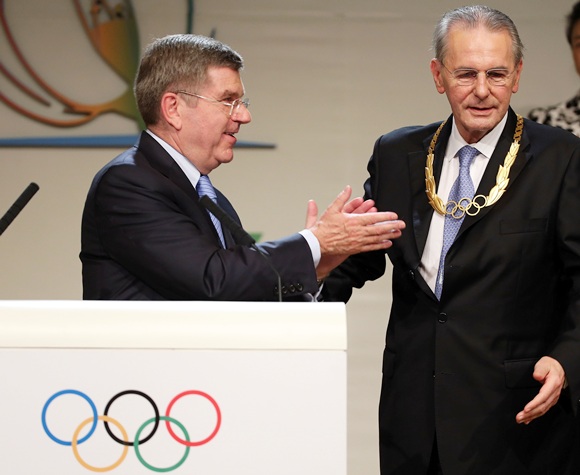 President of the IOC Jacques Rogge receives the Olympic Order from newly announced ninth IOC President Thomas Bach