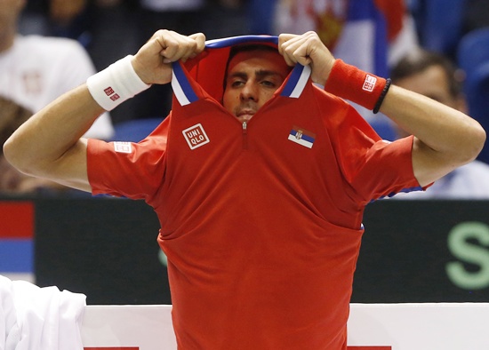 Serbia's Novak Djokovic takes off his shirt