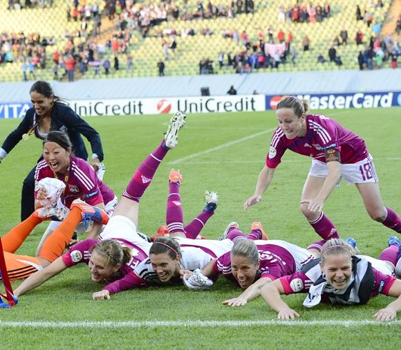 Players of Olympique Lyon dive on the pitch