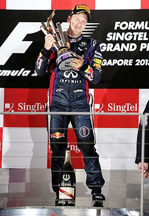 Sebastian Vettel of Germany and Infiniti Red Bull racing lifts the trophy following his victory during the Singapore Formula One Grand Prix
