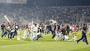 Besiktas fans throw plastic chairs onto the pitch during the Turkish Super League derby soccer match between Besiktas and Galatasaray at Ataturk Olympic Stadium in Istanbul on Sunday