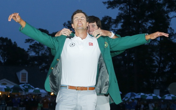 Adam Scott of Australia,left, receives his green jacket from 2012 champion Bubba Watson