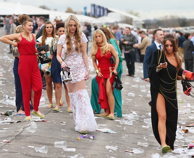 Racegoers swap their shoes for flip flops as they make their way home from Ladies Day