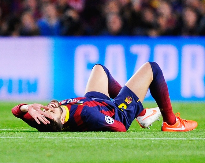 Gerard Pique of Barcelona grimaces before being substituted for an injury