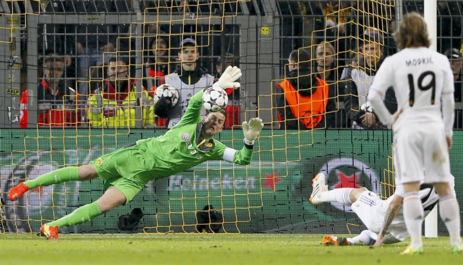 Borussia Dortmund's goalkeeper Roman Weidenfeller saves a penalty shot by Real Madrid's Angel di Maria (second right, covered)