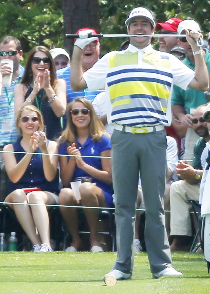 US golfer Bubba Watson bites his club after a good tee shot