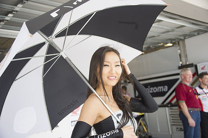 A grid girl smiles in paddock during the MotoGp Grand Prix of The Americas - Free Practice at the Circuit of The Americas on Friday