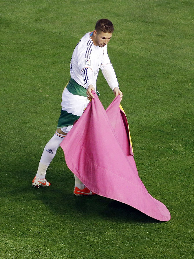 Real Madrid's Sergio Ramos uses a bullfighter's cape as he celebrates their win against Barcelona at the end their King's Cup final on Wednesday