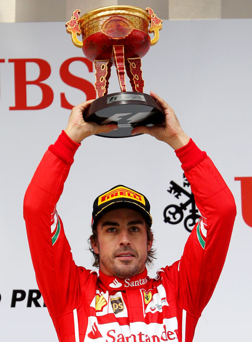 Fernando Alonso of Spain and Ferrari celebrates his third place