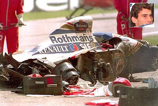 The Rothmans Williams car of Senna lies shattered on the track after he crashed into the concrete barrier