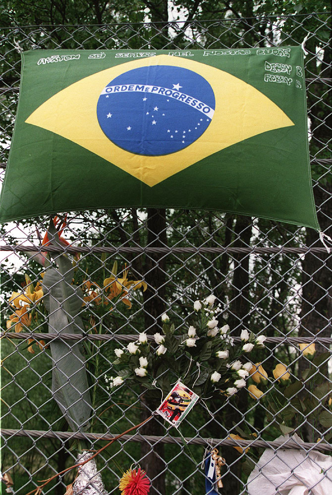 Flowers and mementos line the fencing as a tribute on the corner of the track where Ayrton Senna had crashed at Imola