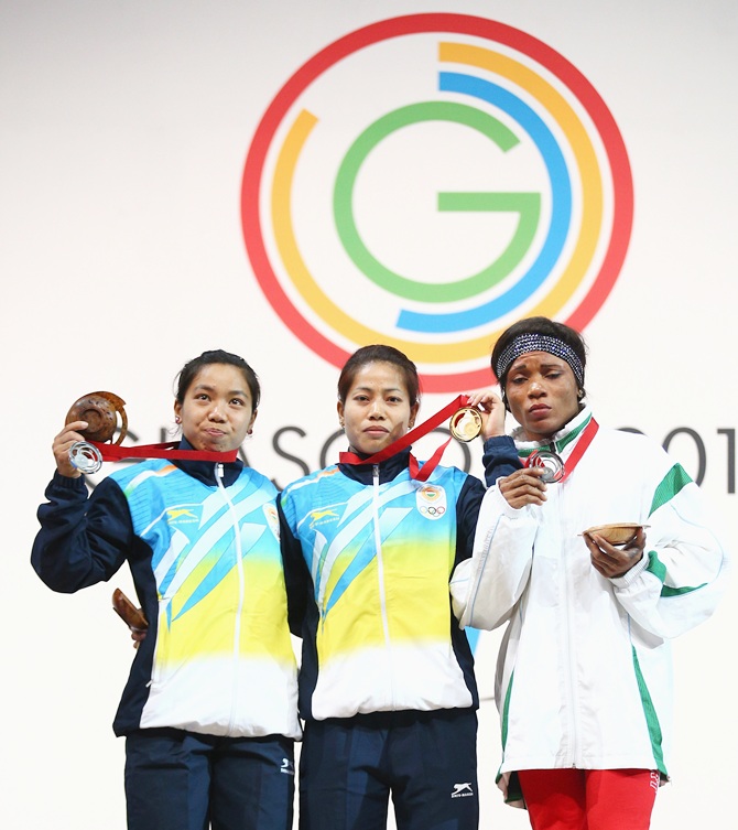 Gold medalist Sanjita Chanu Khumukcham of India (centre), silver medalist Nikechi   Opara of Nigeria (right) and bronze medalist Mirabai Chanu Saikhom of India