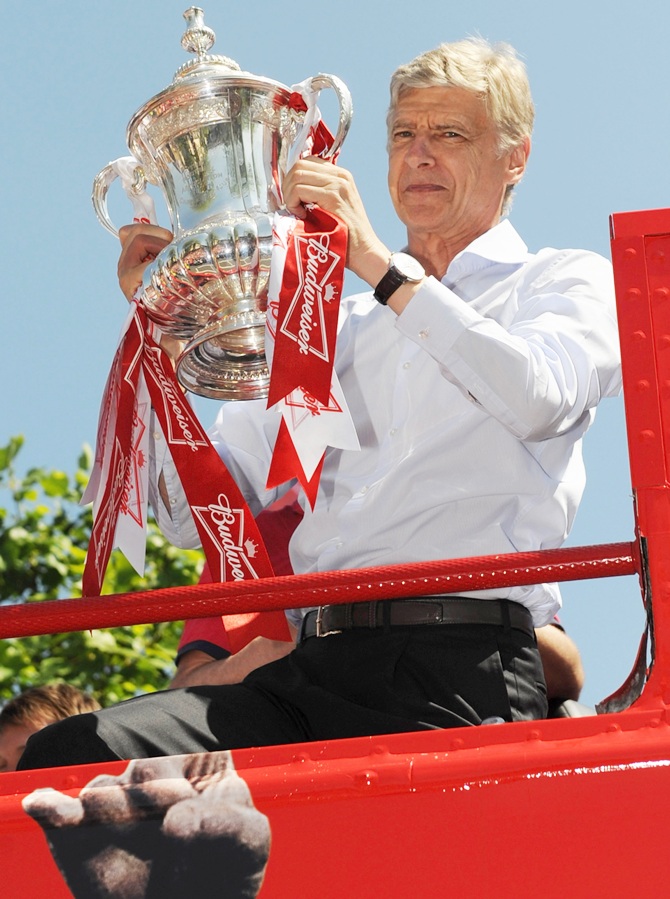 Arsene Wenger the manager of Arsenal FC celebrates with the FA Cup onboard the Arsenal team bus