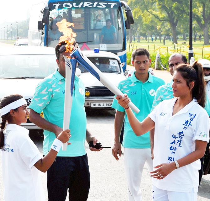Squash player Dipika Pallikal, right, during the torch relay ceremony of 17th Asian Games 2014 at Rajpath in New Delhi on Saturday