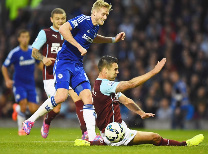 Andre Schurrle of Chelsea leaps over the challenge from Jason Shackell of Burnley