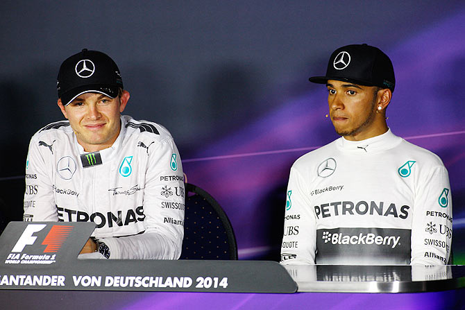 Nico Rosberg of Germany smiles next to teammate Lewis Hamilton of Great Britain