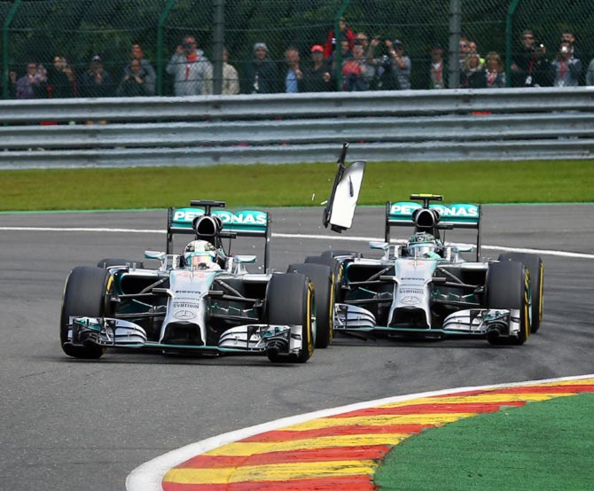 Debris flies in the air as Nico Rosberg (right) of Mercedes GP makes contact with team mate Lewis Hamilton