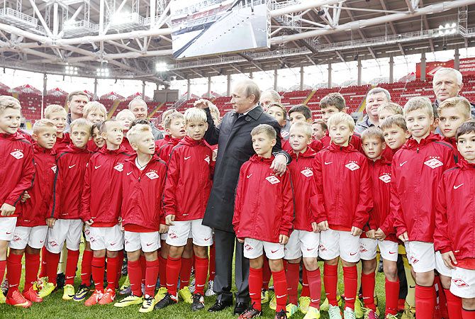 Russian President Vladimir Putin talks to young soccer players during unveiling of Spartak's stadium Otkrytie Arena in Moscow in August 2014