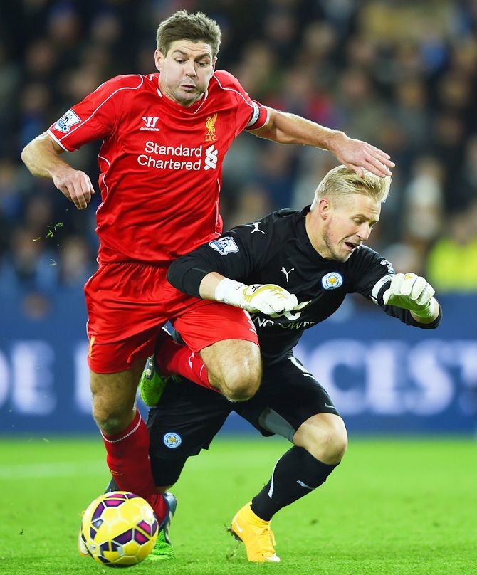 Steven Gerrard of Liverpool collides with Kasper Schmeichel of Leicester City
