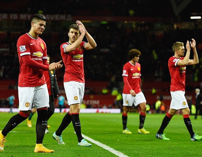 Marcos Rojo and Michael Carrick of Manchester United applaud the fans