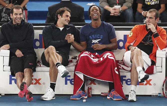 (L-R) Pete Sampras, Roger Federer, Gael Monfils and Cedric Pioline of the Micromax Indian Aces share a moment during their match against the Singapore Slammers at the International Premier Tennis League (IPTL) in New Delhi