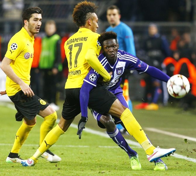 Borussia Dortmund's Pierre-Emerick Aubameyang, centre, fights for the ball with Anderlecht's   Fabrice N'Sakala