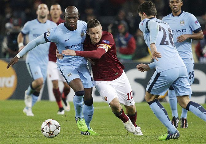 AS Roma's Francesco Totti (centre) is challenged by Manchester City's Eliaquim Mangala (left)