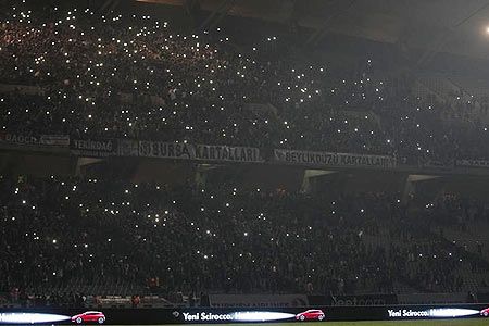 Fans stand in darkness in the tribune of the Ataturk Olimpiyat Stadium following a power outage during the Europa League Group C soccer match between Besiktas and Tottenham Hotspur, in Istanbul on Thursday