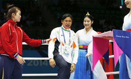  India's L Sarita Devi cries looking at a medal as she steps on to the podium helped by bronze medalist Vietnams Thi Duyen Luu during the medal ceremony for the women’s light 60-kilogram division boxing at the 17th Asian Games in Incheon