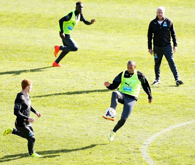 Yoan Gouffran controls the ball while manager Alan Pardew looks on during a Newcastle United   training session