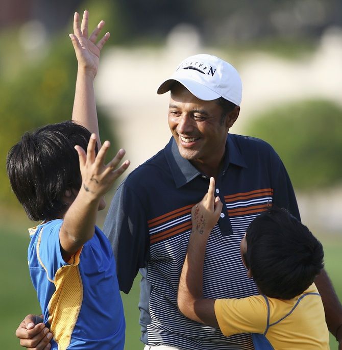 Arjun Atwal of India hugs his children Krishna and Shiva after winning the Dubai Open