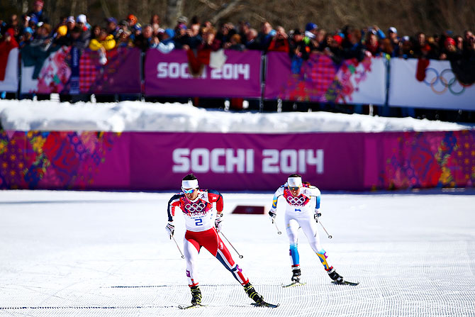Marit Bjoergen of Norway approaches the finish line ahead of Charlotte Kalla of Sweden to win gold in the Ladies' Skiathlon.
