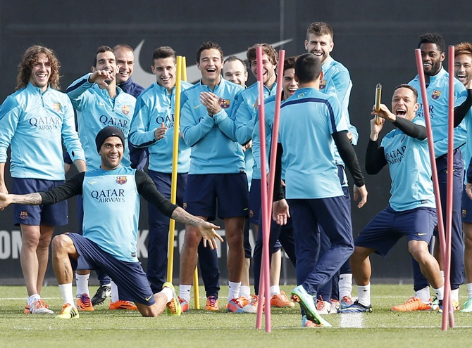 Barcelona's soccer players joke as they look at teammate Alexis Sanchez.