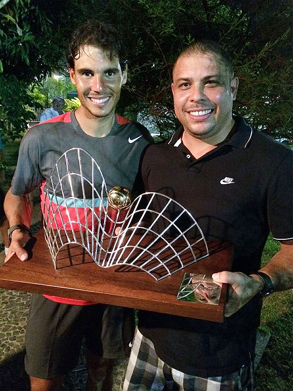 Rafael Nadal receives the trophy from former Brazil footballer Ronaldo after winning the Rio Open on Sunday