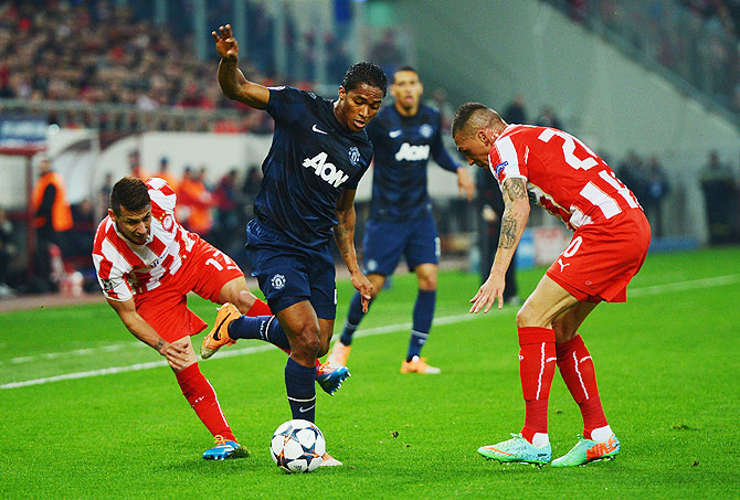Jose Holebas (right) and Hernan Perez (left) of Olympiacos challenge Antonio Valencia (centre) of Manchester United during their UEFA Champions League match on Tuesday