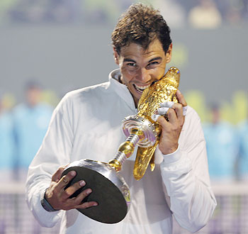 Rafael Nadal of Spain poses with his trophy after winning the Qatar Open final tennis match in Doha on Saturday