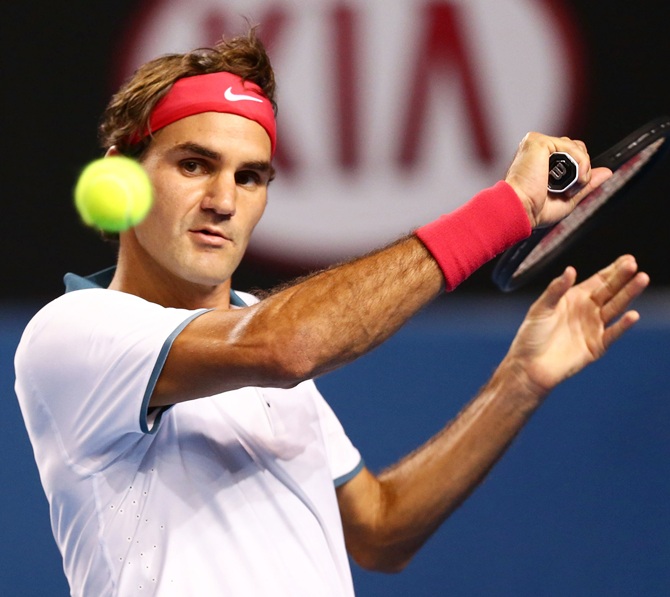 Roger Federer of Switzerland plays a forehand in his second round match against Blaz Kavcic of Slovenia