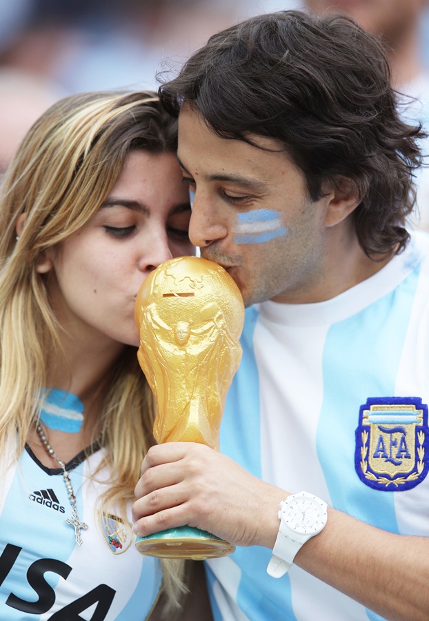 Argentina fans kiss a replica of the World Cup trophy